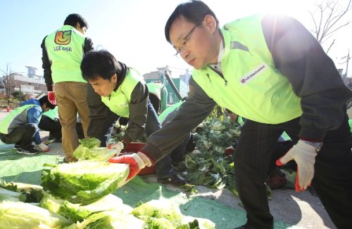 Employees of LG Electronics’ Pyeongtaek plant participate in a social contribution event to make kimchi for seniors at a community center in the region on Monday. (LG Group)