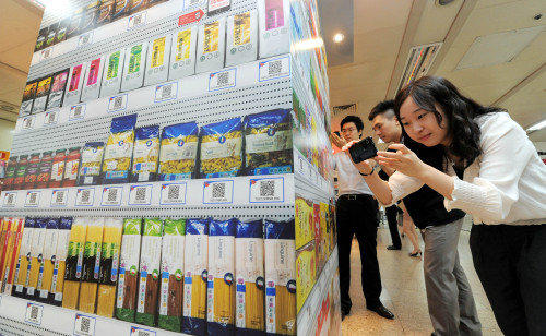 Customers scan the image of products using a Homeplus shopping app at Seolleung Station in Yeoksam-dong, southern Seoul. (Ahn Hoon/The Korea Herald)