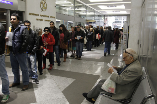 Consumers of Public Power Company, DEH, wait in a line to pay the new emergency property tax in Athens on Tuesday. (AP-Yonhap News)