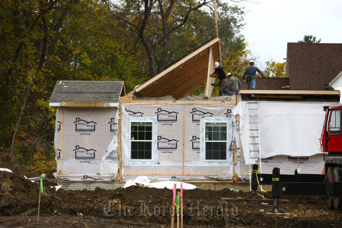 Workers lift the roof of a Champion Home Builders Inc. sectional home in Flint, Michigan. (Bloomberg)