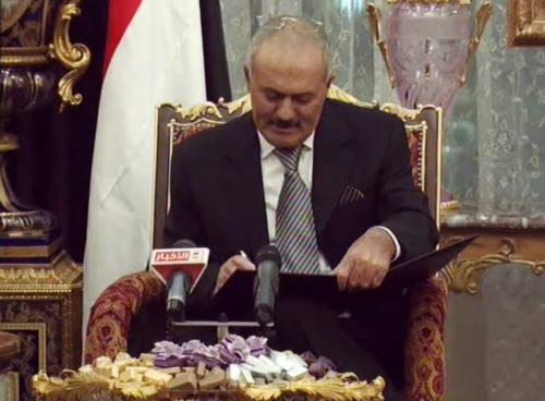 Yemeni President Ali Abdullah Saleh signs a document agreeing to step down in Riyadh, Saudi Arabia, Wednesday. (AP-Yonhap News)