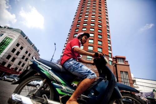 A man on a motor bike rides past the Joint-Stock Commercial Bank for Foreign Trade of Vietnam,  headquarters in Hanoi, Vietnam (Bloomberg)