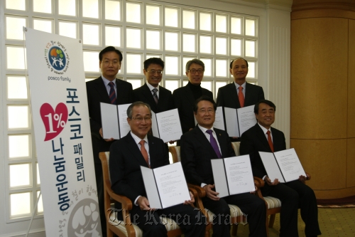 (Counterclockwise from front left) POSCO’s outside directors ― vice chairman of Samchully Co. Han Joon-ho, honorary professor at Ewha Womans University Yoo Jang-hee, Hallym University president Lee Young-sun, former vice president of LG Electronics Nam Yong, president of Humax Co. Byun Dae-gyu, Seoul National University professor Lee Chang-hee and lawyer Park Sang-gil ― pose after signing an agreement to donate 1 percent of their paychecks. (POSCO)