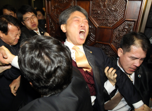The Korea-U.S. FTA was passed in the National Assembly on Nov. 22 in a chaotic session during which Democratic Labor Party lawmaker Kim Sun-dong (center) set off tear gas.