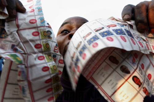 Supporters of opposition candidate Etienne Tshisekedi parade what they claim are badly printed fraudulent photocopies of election ballots they say they found in the Bandal commune in Kinshasa, Monday. (AP-Yonhap News)