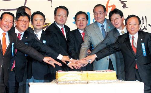 Top officials of the ruling Grand National Party cut a cake during a ceremony commemorating its 14th anniversary last week. (Yonhap News)