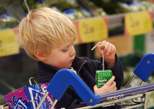 A boy opens an apple juice at the Tesco store in west London (Bloomberg)