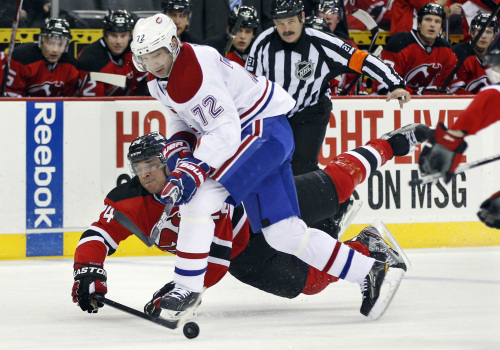 The New Jersey Devils’ Bryce Salvador (24) and the Montreal Canadiens’ Erik Cole challenge for the puck. (AP-Yonhap News)