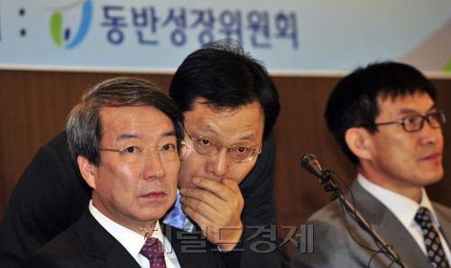 Shared growth commission chief Chung Un-chan (left) listens to a panel official during the committee meeting on Tuesday. (Kim Myung-sub/The Korea Herald)