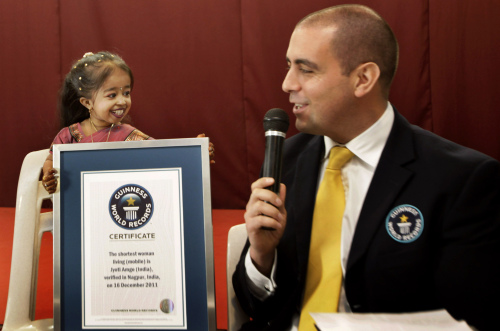 Guinness World Records adjudicator Rob Molloy (right) confers the title of the shortest woman of the world to Jyoti Amge in Nagpur, India, Friday.( AP-Yonhap News)