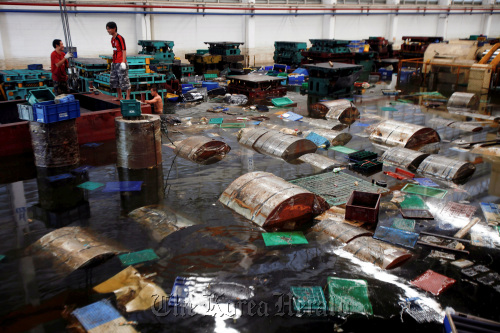 Aapico Hitech Pcl workers recover containers and raw steel rolls at the company’s flooded factory in the Hi Tech Industrial estate, Ayutthaya, Thailand. (Bloomberg)