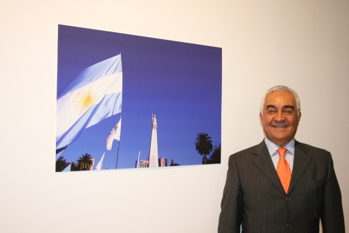 Argentine Ambassador to Korea Carlos Alberto Arganaraz stands next to a photo at the Buenos Aires exhibition in Seoul on Tuesday. (Kirsty Taylor/The Korea Herald)