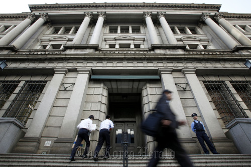 Pedestrians walk past the Bank of Japan headquarters in Tokyo. (Bloomberg)