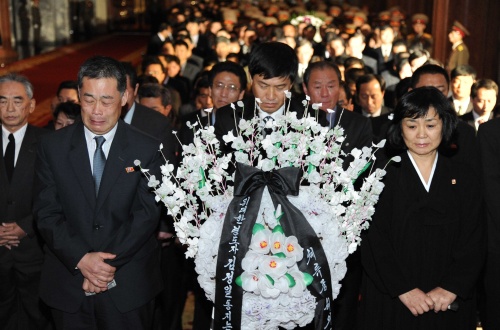 Mourners carry a wreath as they arrive to pay respects to the body of North Korean leader Kim Jong Il at the Kumsusan Memorial Palace in Pyongyang, North Korea Tuesday Dec. 20, 2011. (AP-Yonhap News)