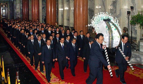 Senior officers carry a large flower wreath for late North Korean leader Kim Jong-il at the Kumsusan Memorial Palace, where his body is lying in state, in Pyongyang on Tuesday. (AFP-Yonhap News)
