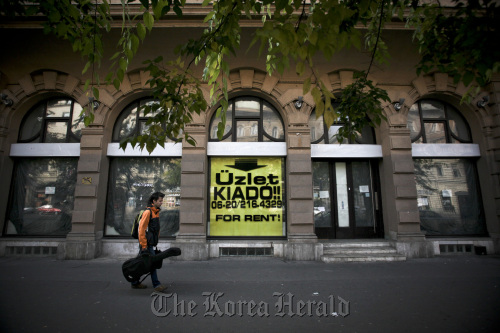 A pedestrian walks past shop premises advertised for rent in Budapest, Hungary. (Bloomberg)