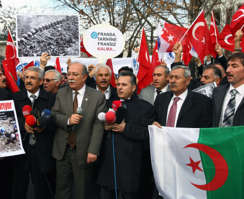 Members of a Turkish union hold Turkish and Algerian flags as they protest against France outside the French Embassy in Ankara on Thursday. (AP-Yonhap News)