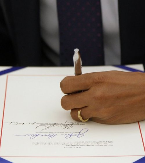 President Barack Obama signs the payroll tax cut extension, Friday in the White House Oval Office in Washington. (AP-Yonhap)