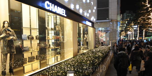 People walk past a Chanel shop in downtown Seoul. (Lee Sang-sub/The Korea Herald)