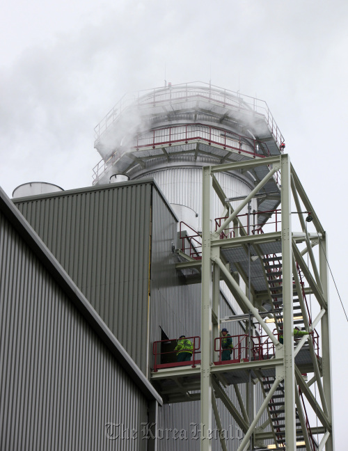 The Dong Energy company logo stands alongside an electricity pylon at the company’s gas fired Severn power station in Newport, South Wales, U.K. (Bloomberg)