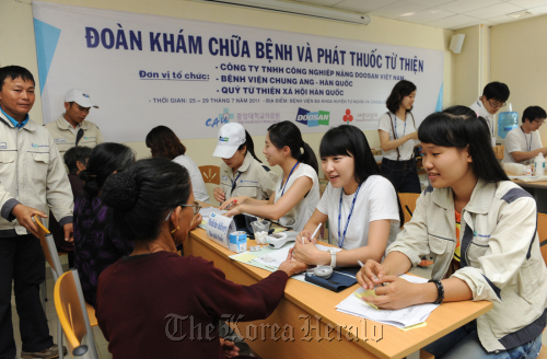 Doosan VINA officials and Chung-Ang University Hospital medical team staff offer medical support to Vietnamese. (Doosan)