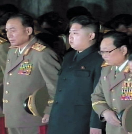 Kim Jong-un flanked by his aides