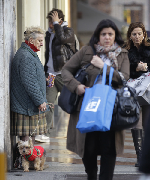 An elderly woman begs in downtown Milan. (Bloomberg)