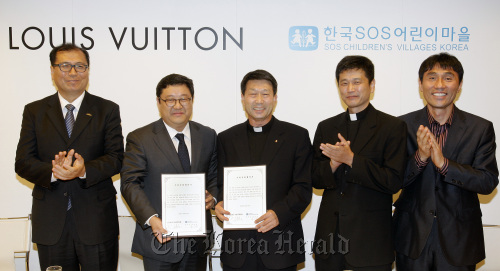 Andy Kim (second from left), human resources manager at Louis Vuitton Korea, poses with officials from SOS Children’s Villages after signing an agreement on cooperation in social contributions in November. (Louis Vuitton Korea)