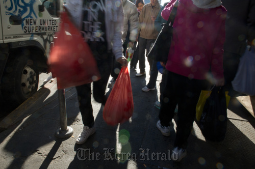 Pedestrians carry plastic shopping bags while walking through the Chinatown area in San Francisco, California. (Bloomberg)