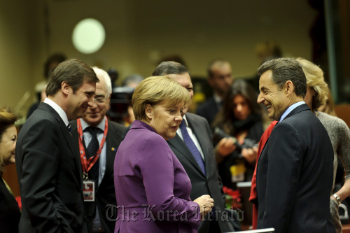 Left to right, Pedro Passos Coelho, Portugal’s prime minister, Angela Merkel, Germany’s chancellor, and Nicolas Sarkozy, France’s president, speak ahead of the summit of European Leaders at the European Council headquarters in Brussels on Dec. 9. (Bloomberg)