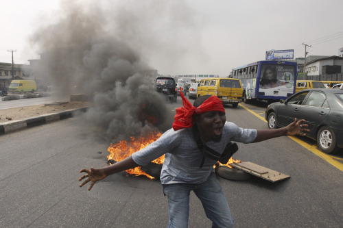 A protester shouts in front of a fire on a major road during a fuel subsidy protest in Lagos, Nigeria on Tuesday. (AP-Yonhap News)