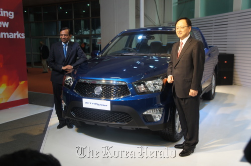 Ssangyong Motor CEO Lee Yoo-il (right) and Pawan Goenka, president of Mahindra & Mahindra, pose with Korando Sports at the New Delhi Auto Expo on Thursday. (Ssangyong Motor)