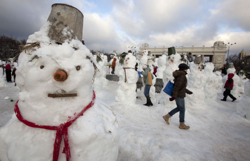 People walk between dozens of snowmen assembled in Gorky Park in Moscow, Russia, Monday, Jan. 2, 2012. (AP)