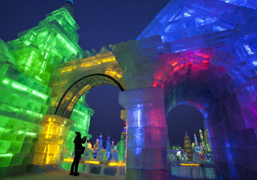 A woman takes picture of the colorful buildings made from blocks of ice during the opening ceremony of the Harbin International Ice and Snow festival in Harbin in northeastern's China's Heilongjiang province, Thursday, Jan. 5, 2012. (AP)