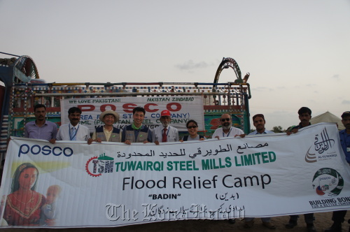 POSCO employees pose at a flood relief camp in Pakistan where they provided essential supplies for workers at the company’s affiliate Tuwairqi Steel Mills in late September. (POSCO)