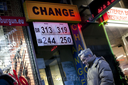 A pedestrian passes a currency exchange store advertising forint exchange rates with euros and dollars in central Budapest. (Bloomberg)