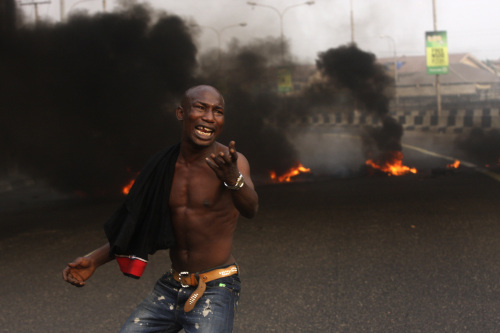 An angry youth protests in front of a burning barrier in Lagos, Nigeria on Tuesday. (AP-Yonhap News)