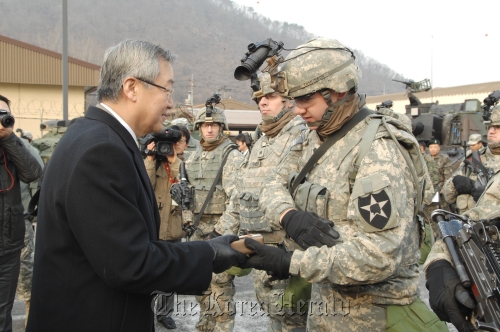 Minister of Foreign Affairs and Trade Kim Sung-hwan (left) hands a gift to a U.S. soliders at the U.S. Army’s 2nd Infantry Division in Dongducheon, 40 kilometers north of Seoul, on Friday. (Ministry of Foreign Affairs and Trade)