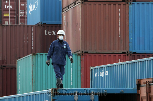 A man walks on a container at a shipping terminal in Tokyo. (Bloomberg)