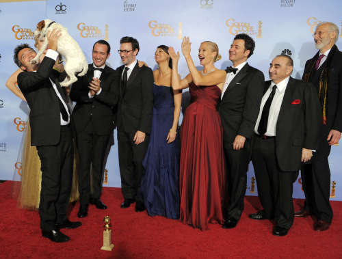 The cast and crew of the film “The Artist” pose backstage with the award for Best Motion Picture ― Comedy or Musical. From left are Thomas Langmann, Uggie, Jean Dujardin, Michel Hazanavicius, Berenice Bejo, Penelope Ann Miller, Ludovic Bource, Ken Davitian and James Cromwell. (AP-Yonhap News)