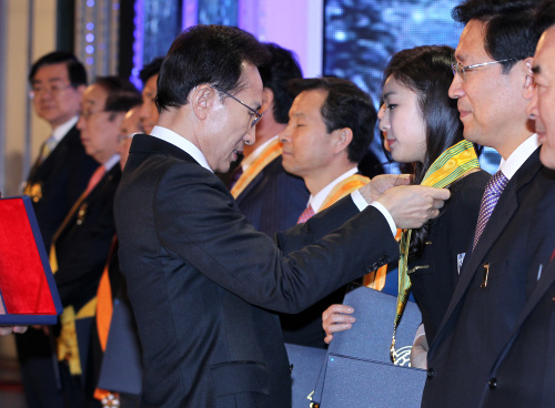 President Lee Myung-bak presents a medal to Kim Yu-na during a special rally for the 2018 Olympics in PyeongChang, Gangwon Province on Tuesday. (Yonhap News)