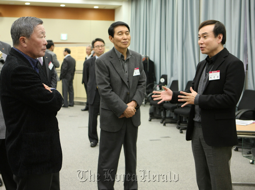 LG Group chairman Koo Bon-moo (left) listens to Cha Suk, vice chairman of LG Household and Healthcare before attending a meeting with CEOs of group affiliates on Tuesday. At center is LG Chem CEO Kim Bahn-suk. (LG Group)