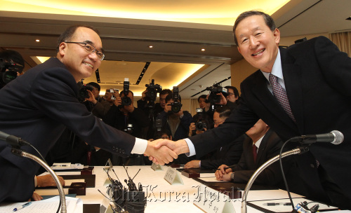 Finance Minister Bahk Jae-wan (left) shakes hands with FKI chairman Huh Chang-soo before starting a meeting with heads of major business lobby groups in Seoul on Thursday. (Yonhap News)