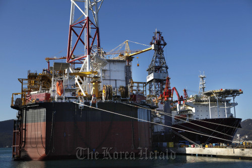 The Pazflor floating production, storage and offloading facility (left) and a drill ship ordered by a Brazilian company are moored at the Daewoo Shipbuilding & Marine Engineering Co. shipyard in Geoje, South Gyeongsang Province. (Bloomberg)