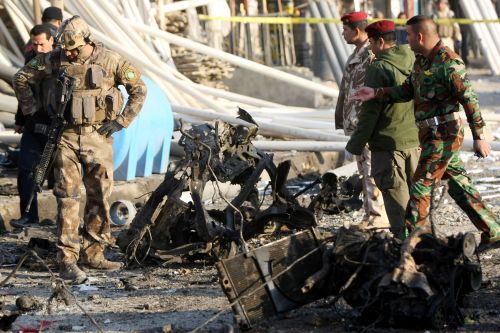 Iraqi security forces inspect the site of a blast after a bomb ripped through a group of workers in Sadr City in Baghdad on January 24, 2012. (AFP)