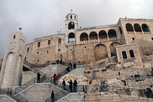 In this photo taken during a government-organized tour for the media, people climb the stairs to the Sednaya Convent, which was damaged by artillery fire Sunday in Sednaya, north of Damascus, Syria, Tuesday, Jan. 31, 2012. No casualties were reported in the attack, which the Syrian government blamed on 