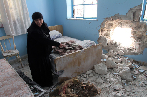 Sister Verona, head of the Sednaya Covent, shows journalists a damaged room which was attacked by artillery fire Sunday in Sednaya. (AP)