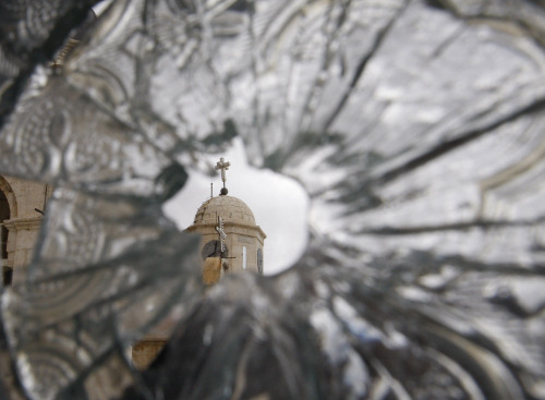 A church dome is seen through a broken window of the Sednaya Convent, which was damaged by artillery fire Sunday in Sednaya. (AP)