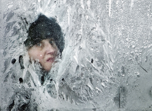 A woman looks out of a window covered in frost on a bus in Bucharest, Romania, Thursday. (AP-Yonhap News)