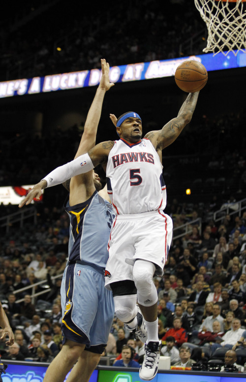 Atlanta Hawks power forward Josh Smith (front) drives past Memphis Grizzlies center Marc Gasol while scoring in the first quarter in Atlanta on Thursday. (AP-Yonhap News)